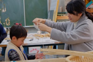 糸を紡ぐ大学生と女の子