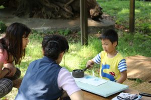 子どもが昔のアイロン“火のし”をかける様子