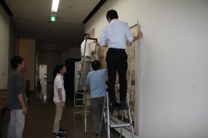 航空写真を展示する学芸員たち