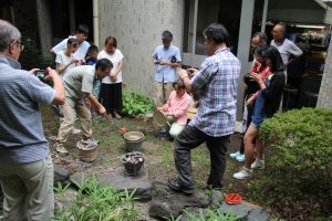 熱した石を土器に投入する栗山学芸員