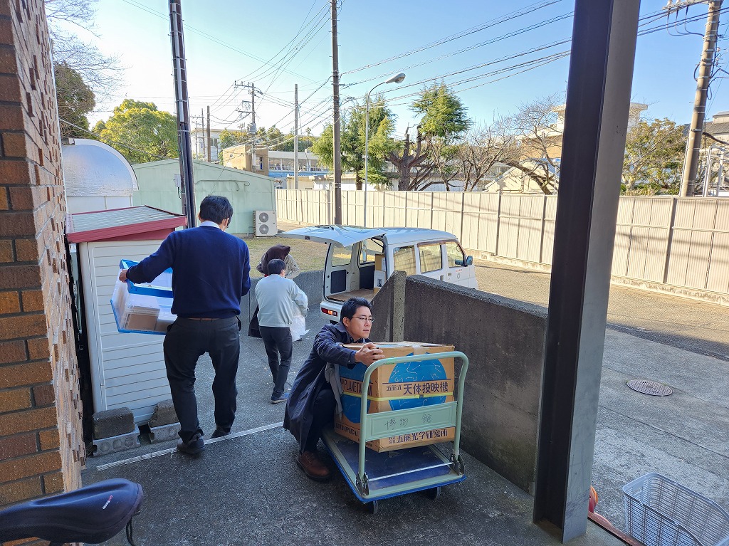 搬入口で台車から手で荷物を運ぶ