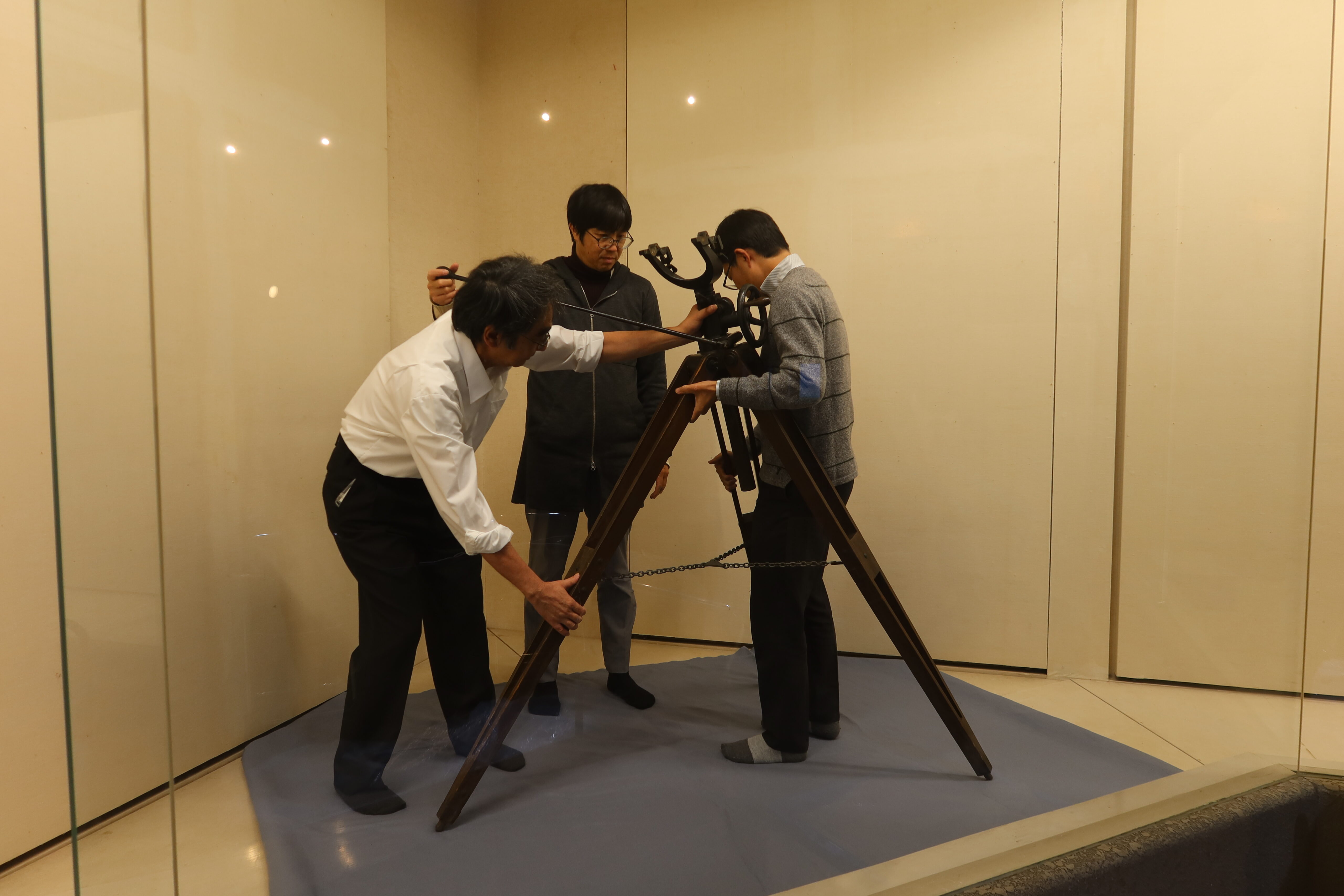 望遠鏡の架台を組み立てる様子。組み立ては3人で行っており、高さは150㎝程度に見える。