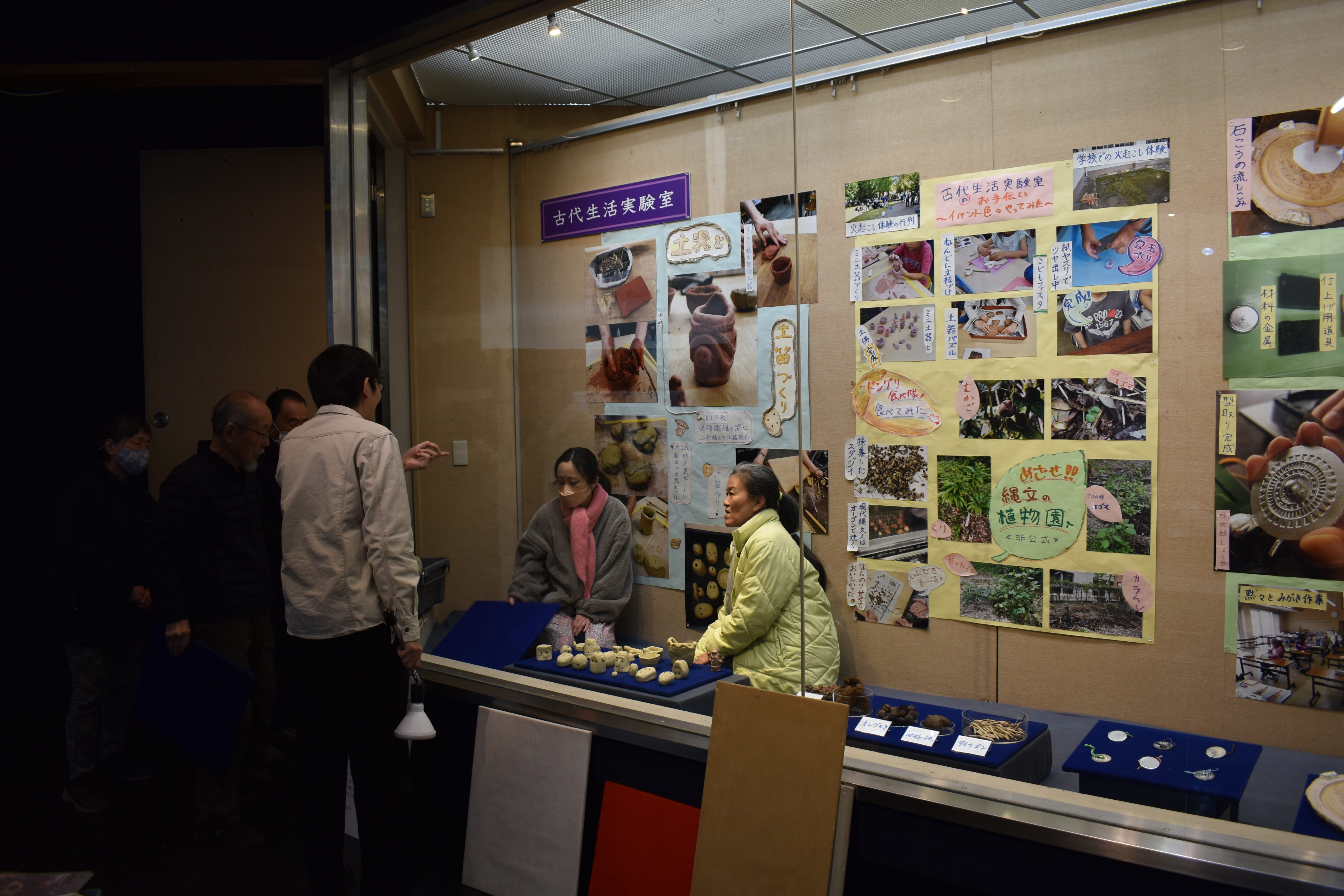 展示室での展示作業の様子。展示ケース内にいる人に外からどう見えるか伝えているところ。