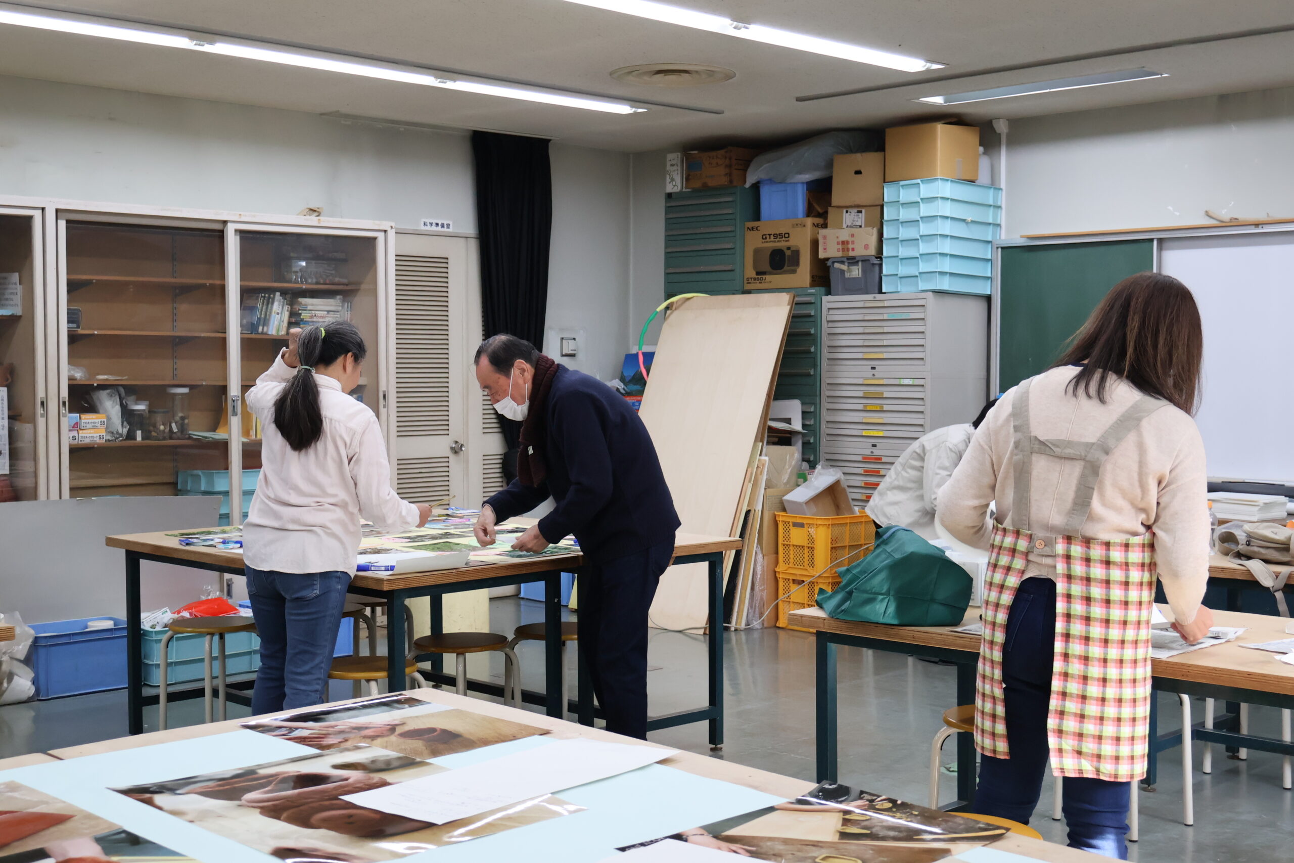 展示用解説紙の作成の様子3つの作業机に分かれて作業している様子がわかる。