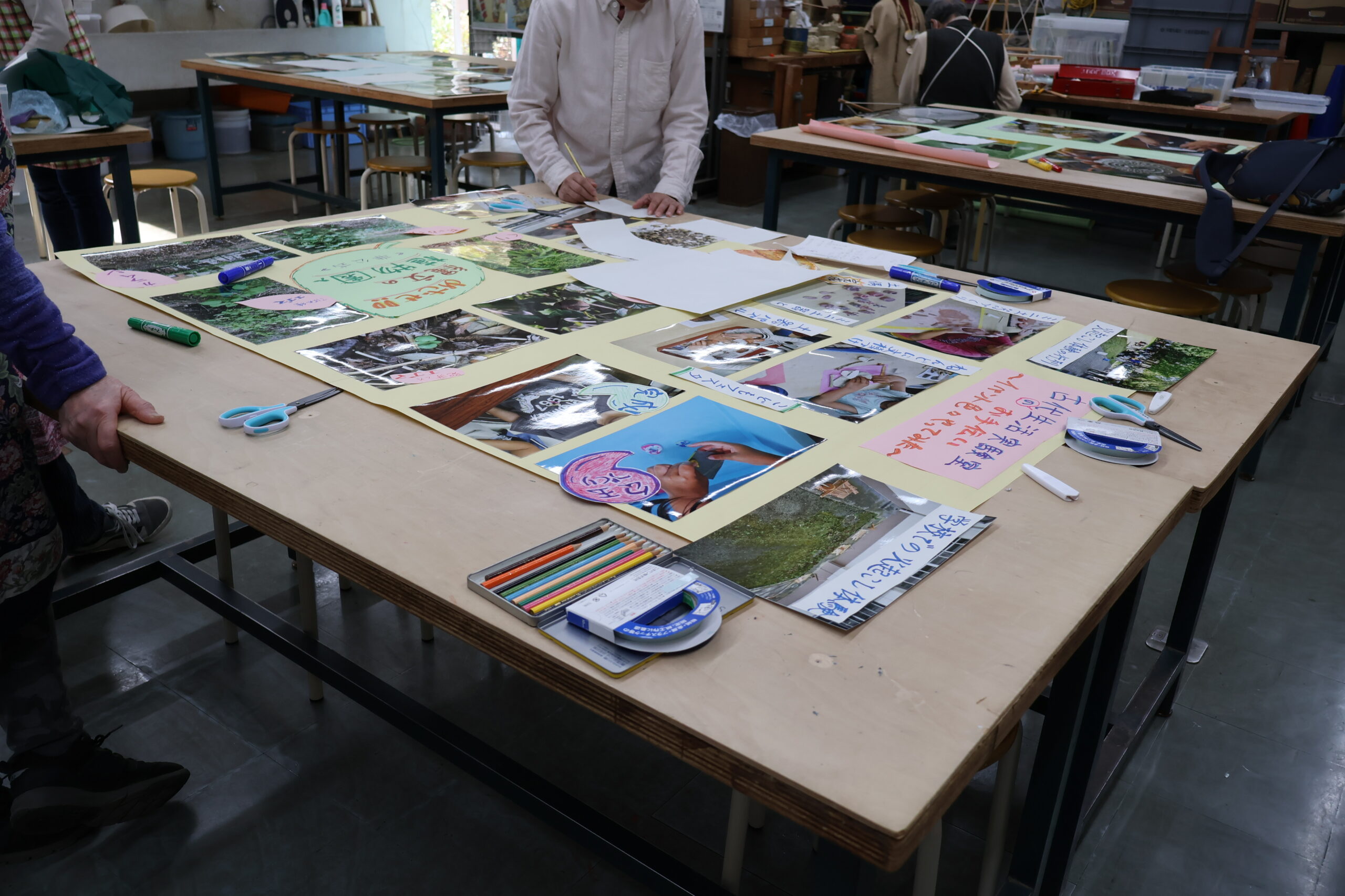 展示で壁に貼る解説作成の様子。模造紙に写真が配置されている。