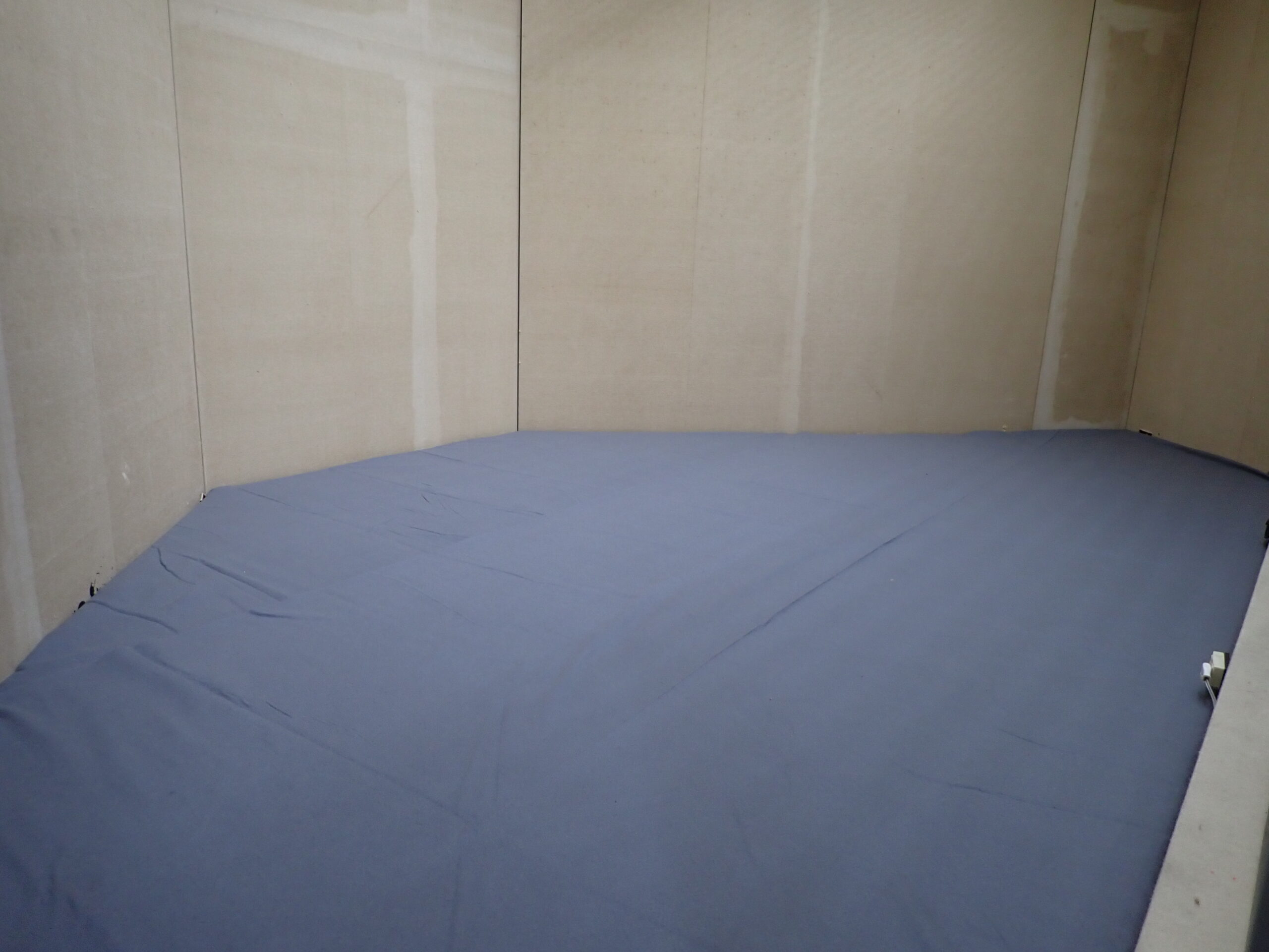 床面に敷かれたフェルト布。ややしわが残る。