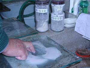 切断した岩石を薄片にするために砥粒で研磨する